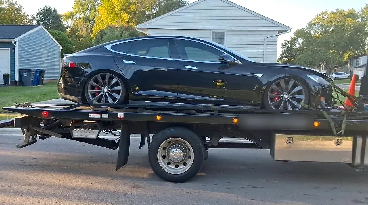 Tesla Model S on a Roadside Towing flatbed, all four wheels off the ground